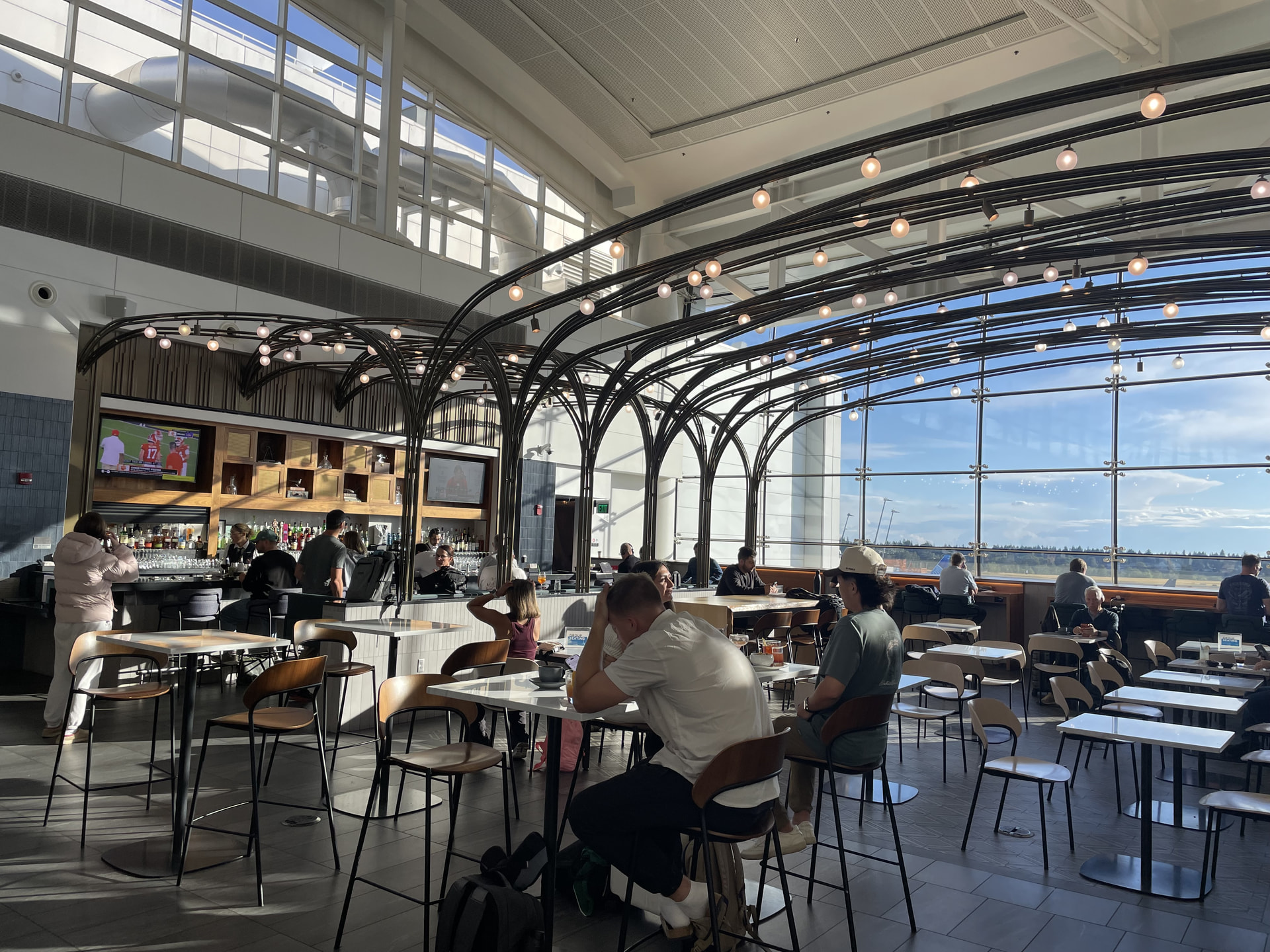 Centurion Lounge 主厅：拱形钢架与整面落地窗