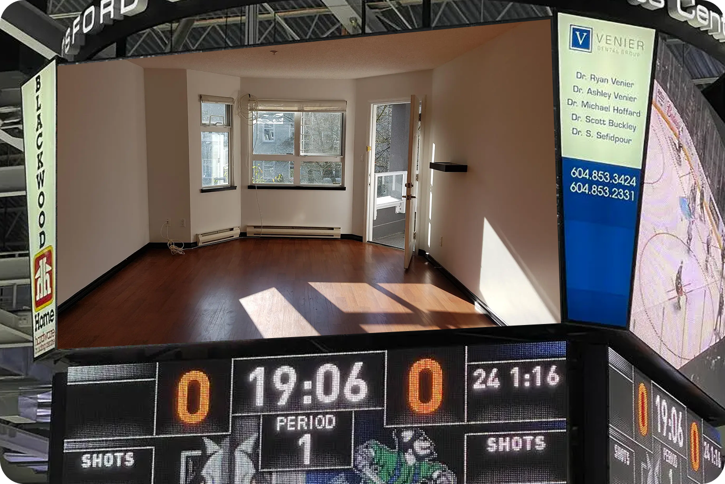 An arena jumbotron showing an empty hardwood floored Vancouver condo living room above a hockey scoreboard reading nil to nil in the first period