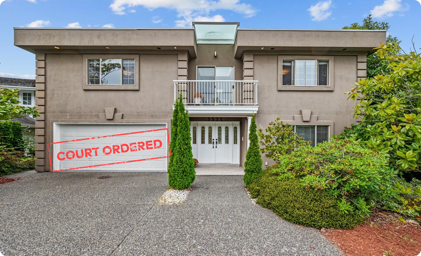 A beige two storey West Vancouver house with a white double garage, a glass skylight and front balcony, stamped Court Ordered in red
